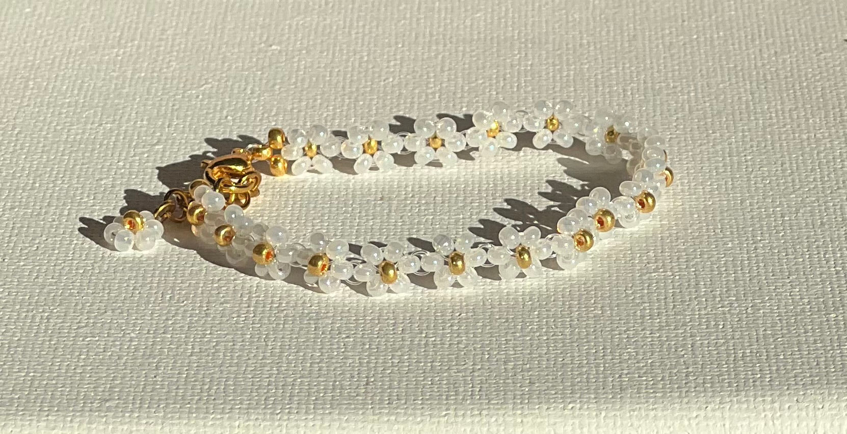 Hvitt Blomstersmykkesett - Ring og Armbånd med Gulldetaljer
